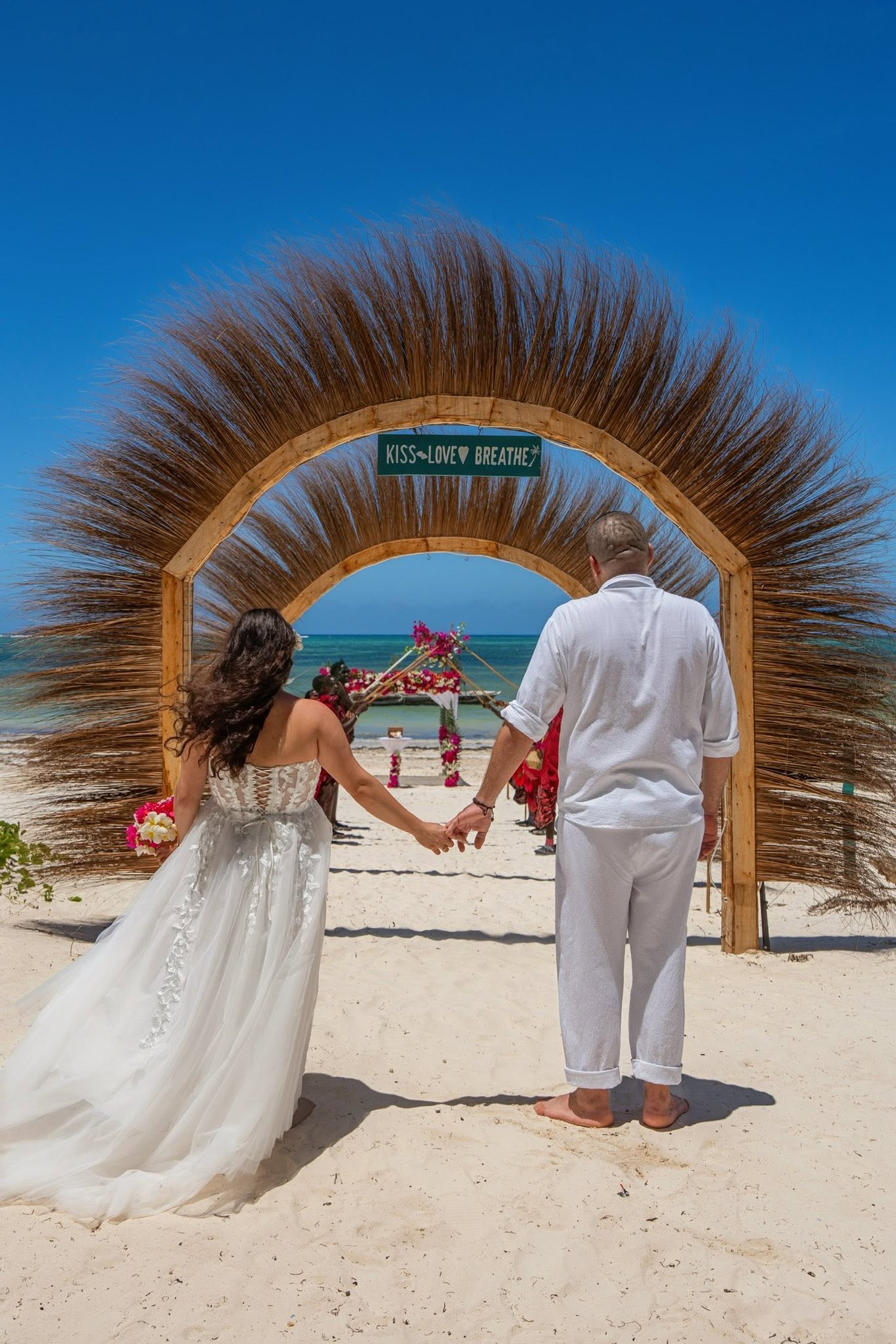 Para młoda podczas ceremonii ślubnej na plaży o zachodzie słońca